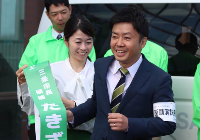 滝沢氏にたすきをかける妻佳代さん