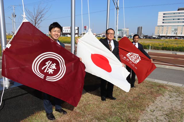 三条ロータリークラブが寄贈、設置した国旗掲揚塔の前で左から滝沢会長、渡辺会長、シャハリアル学長