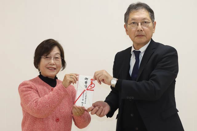 燕市社協の小越会長(左)に寄付を手渡す白根ガスの佐藤取締役