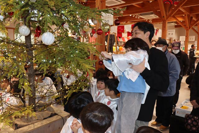 道の駅たがみが設置したクリスマスツリーにオーナメントを下げる田上いずみルーテル幼稚園園児