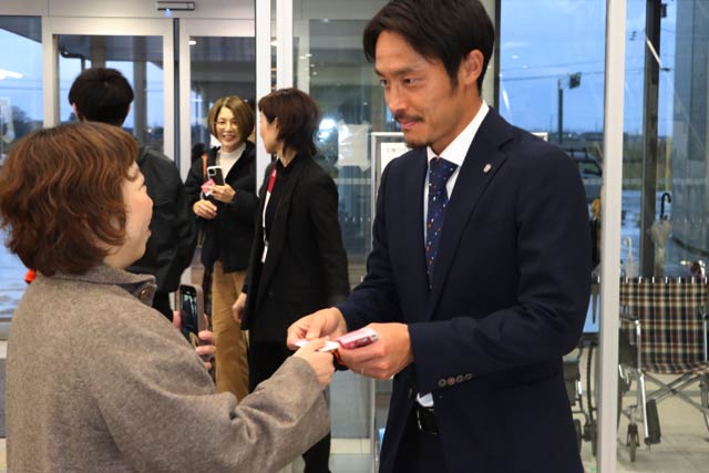 ファン一人ひとりとハイタッチして燕市子育てサポーターの名刺を手渡す島田選手
