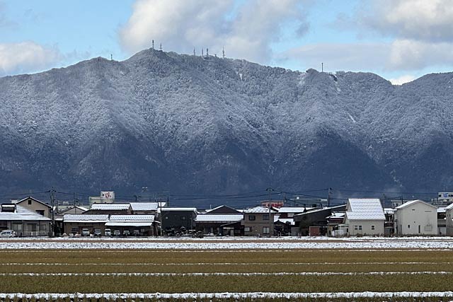 14日朝の中腹から上が雪で白くなった弥彦山