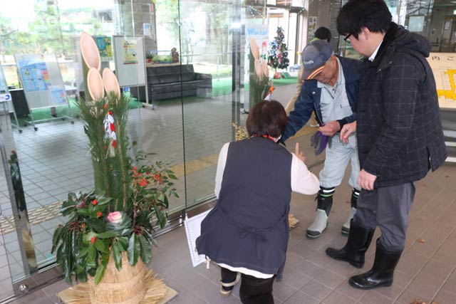 三条市総合福祉センターに門松を設置する西本成寺有志会