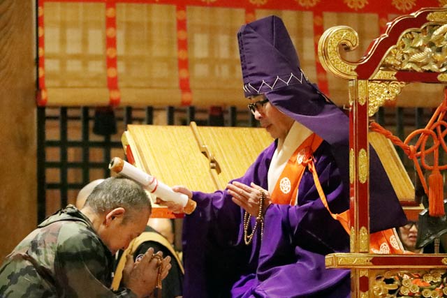 経巻頂戴の儀で参拝者の頭に経巻を載せる鈴木管長