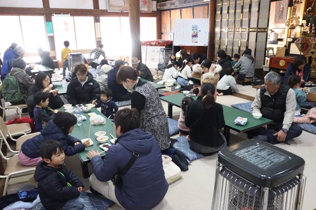 本堂でもちや豚汁を味わう