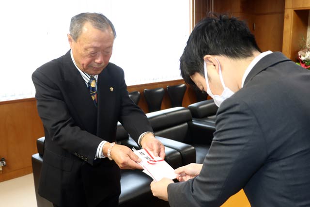 滝沢市長に寄付の目録を手渡す野崎勝康さん