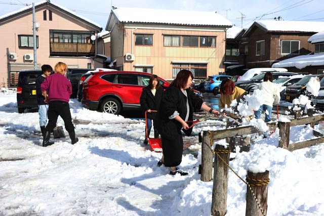 一ノ木戸商店街駐車場でTREEのスタッフが雪かきに励む