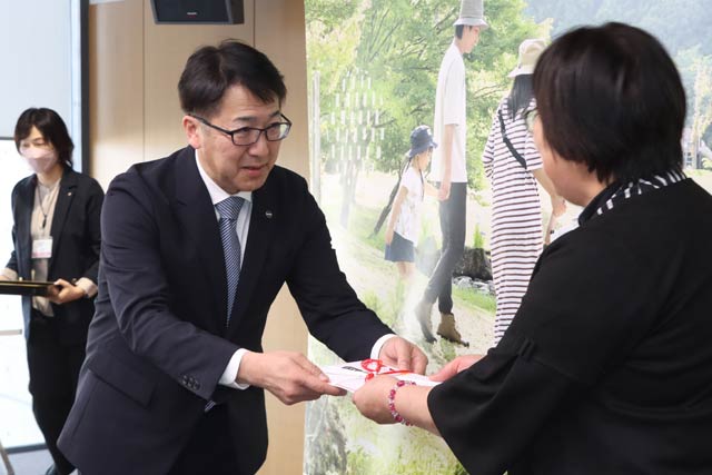 関崎代表に寄付目録を手渡す野水社長