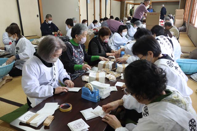 福豆の袋詰め作業に精を出す本成寺婦人会会員