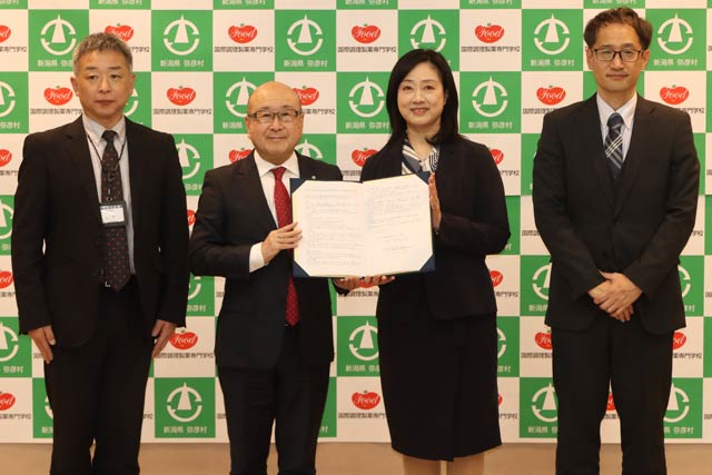 協定書を手に本間村長と石田学校長