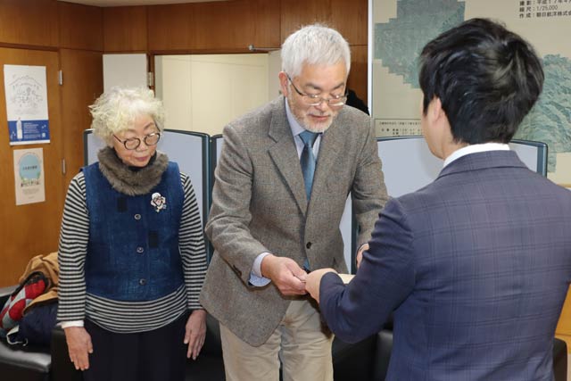 滝沢市長から登録有形文化財の登録証を長屋門の所有者の川俣さんに代わって受けるノジコの会の宗村会長と吉川副会長