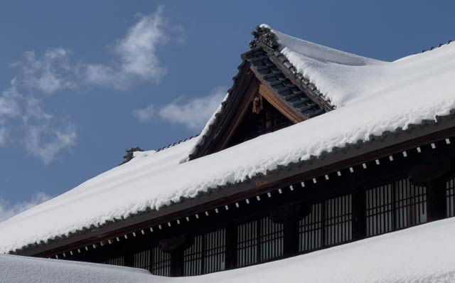 9日午前の三条市歴史民俗産業資料館の屋根を覆った雪の白と青い空のコントラスト