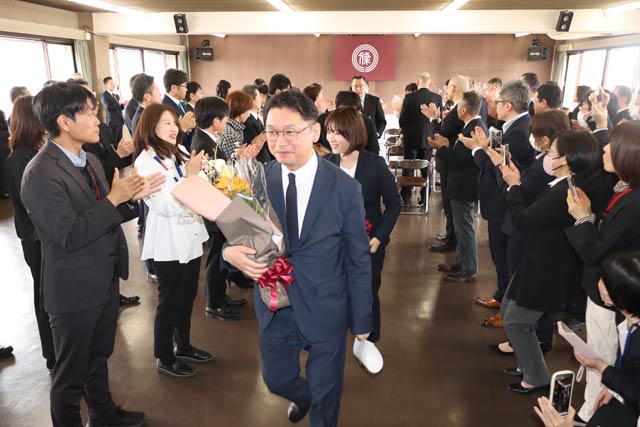 拍手に包まれて退場する退職者
