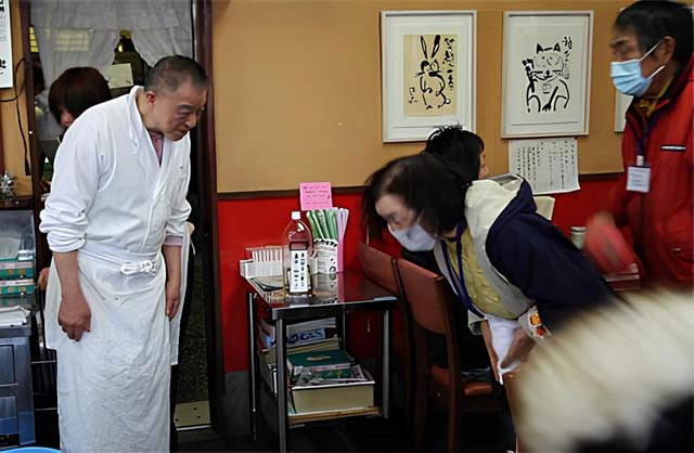 東日本大震災で福島県南相馬市から燕市へ避難していた人たちが杭州飯店のラーメンをごちそうになって勝二さんに頭を下げて礼をする（2011年3月24日）