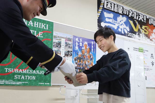 勝利した燕市代表の子どもに今度は「TSUBAME」を上にして飾るプレートを手渡す