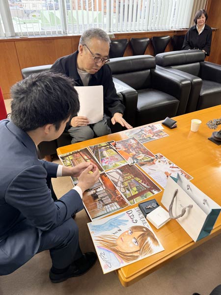 フランスで開かれた個展やワークショップを滝沢市長に紹介するこしのりょうさん