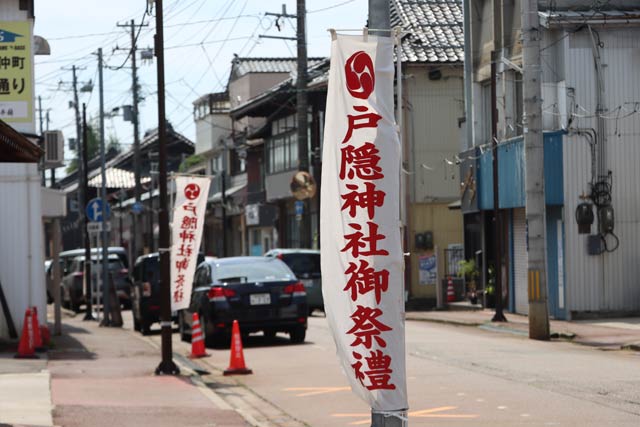 目抜き通りに立つ春季祭礼ののぼり旗