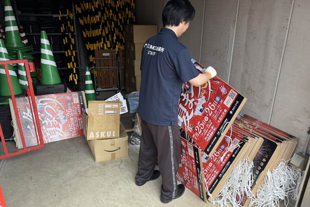 三条商工会議所倉庫で三条夏まつりのポスターを掲示する準備をする職員