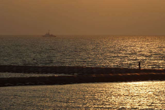 17日夕方、マリンピア日本海（新潟市中央区）付近から夕日に染まりはじめ黄金色にも見える海