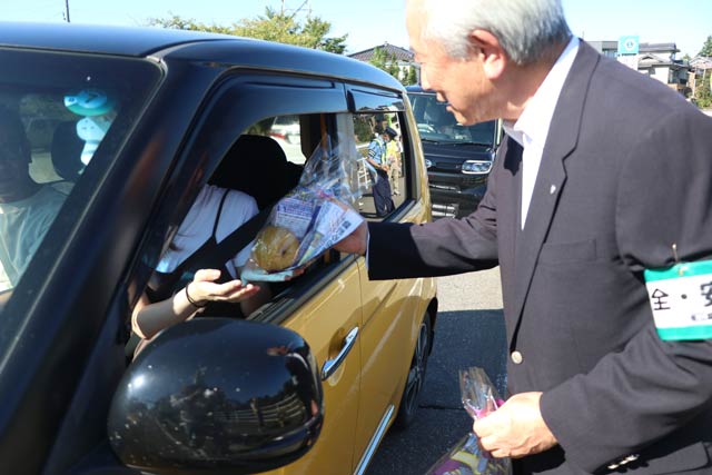 田上町に設置した交通指導所でドライバーにナシを手渡す佐野町長