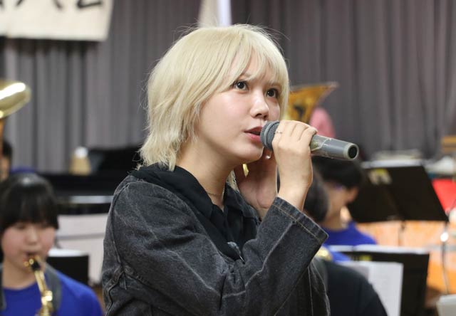 吹奏楽部の演奏で歌う川後さん