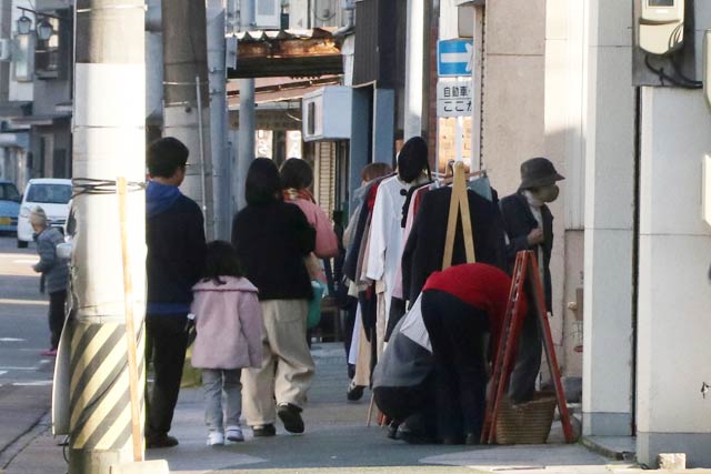 商店街を歩いて参加店をはしごする買い物客