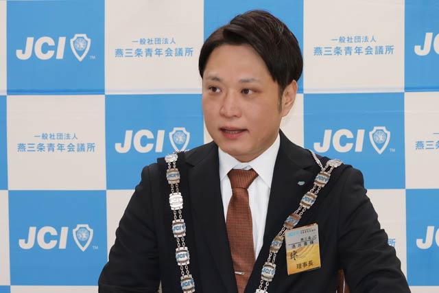 記者会見する酒井理事長
