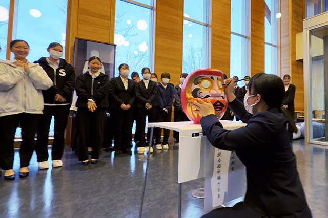 看護学科の開運だるま開眼指揮で目入れする樋口さん