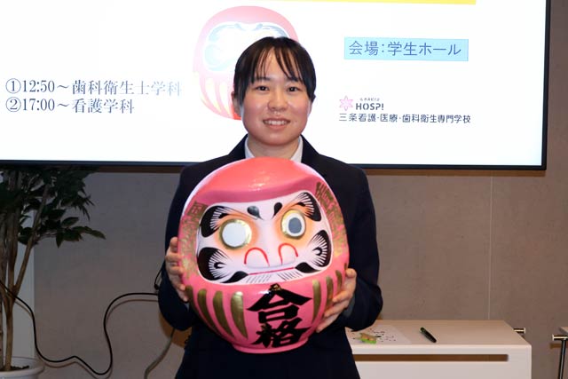 ピンクのだるまに目入れした樋口さん