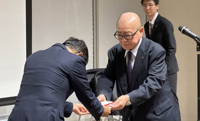 校歌制作費をシャハリアル学長に手渡す高波代表理事