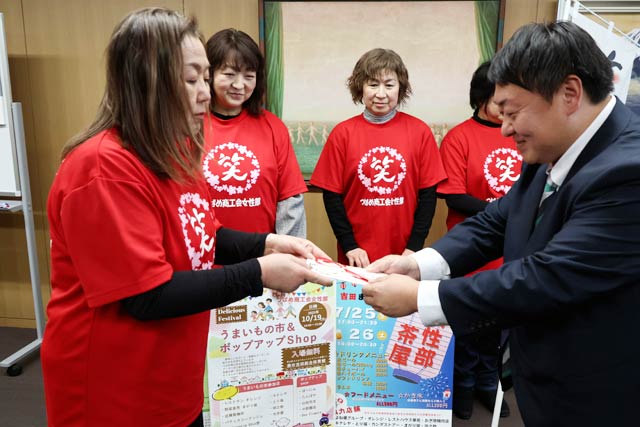 佐野市長に寄付を手渡すつばめ商工会女性部の高浪部長