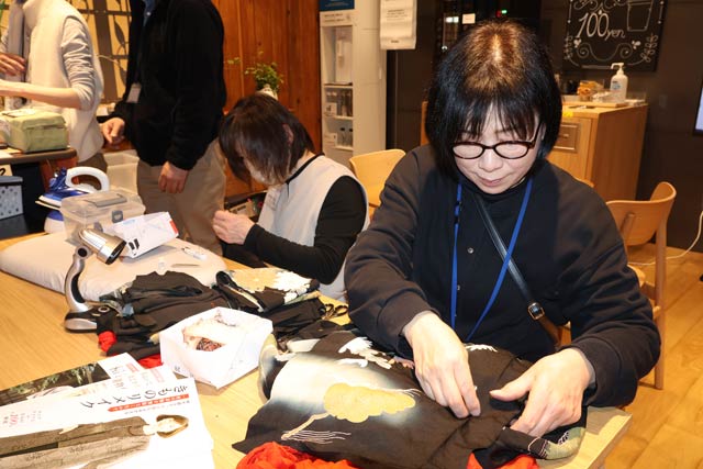 星の輪燕の利用者と職員が着物をほどく作業を実演