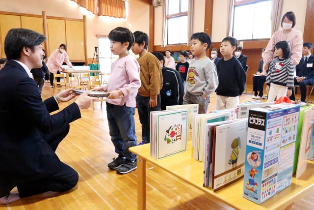 あいせきの相場代表取締役から園児に児童図書を手渡す