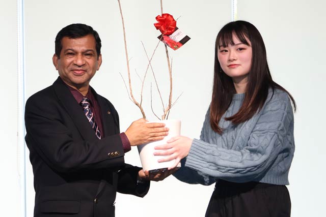 卒業生からサルスベリの苗木を受け取るシャハリアル学長