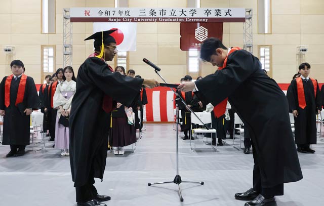 卒業式で学位記のを代表の深澤さんに授与