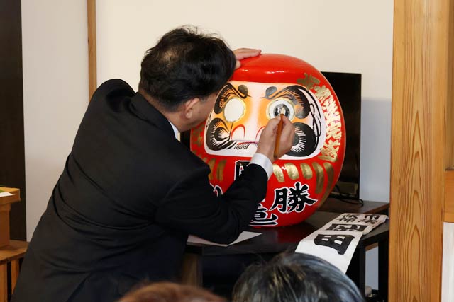 だるまの目入れをする岡田氏