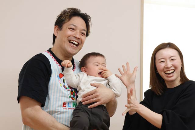 子育て支援センターで親子と記念写真を写る潮崎選手
