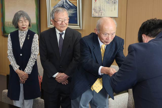 「燕の水道の塔を愛する会」の正副会長だった3人から佐野市長に残ね8.6万円を手渡す