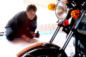 カワサキ「H1 500 Mach III」に向き合ってライブペインティングを行う遠藤信さん