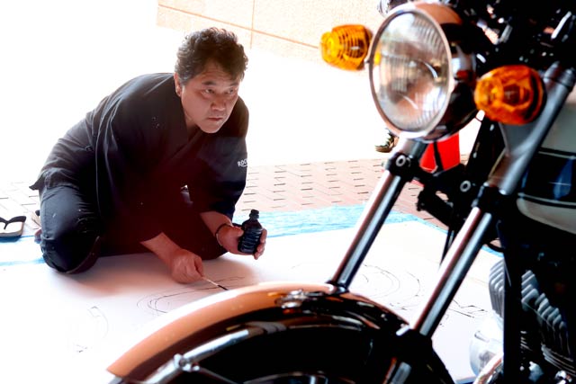 カワサキ「H1 500 Mach III」に向き合ってライブペインティングを行う遠藤信さん