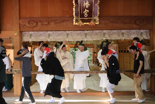 舞い込みで肩車した子どもの頭を神官になでてもらう