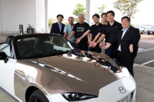 磨き屋シンジケートが鏡面仕上げしたロードスターを燕市長に披露、左から3人目が冨田チェアマン代行