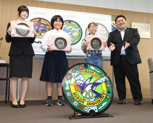 左から優秀作品賞の盛さん、最優秀作品賞の小川さん、優秀作品賞の横山さん、佐野市長と小川さんのデザインで製作された燕市合併20周年記念マンホールふた