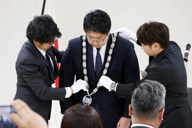 酒井理事長と齋藤直前理事長からプルデンシャルリースを受ける遠藤さん
