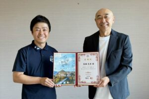 滝沢市長から高橋さんに3期目の委嘱状を手渡した