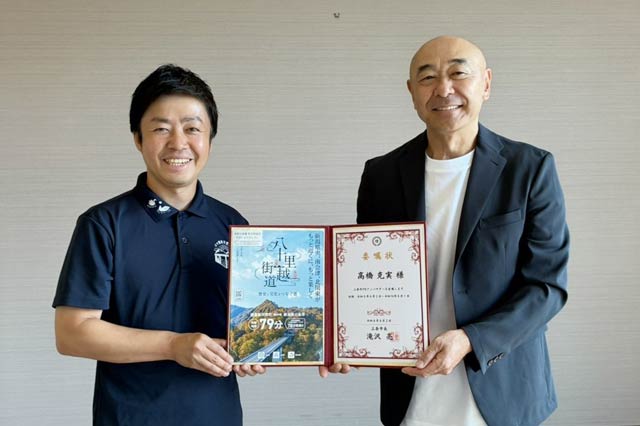 滝沢市長から高橋さんに3期目の委嘱状を手渡した