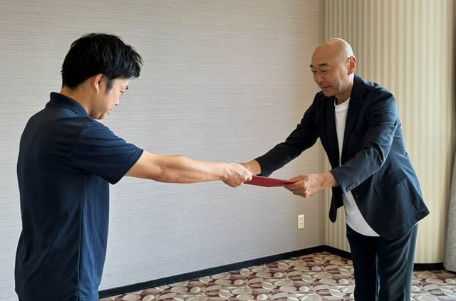 滝沢市長から高橋さんに3期目の委嘱状を手渡した