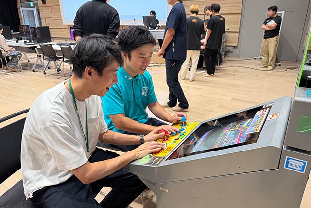 『ストリートファイターII』のテーブル筐体を楽しむ滝沢三条市長