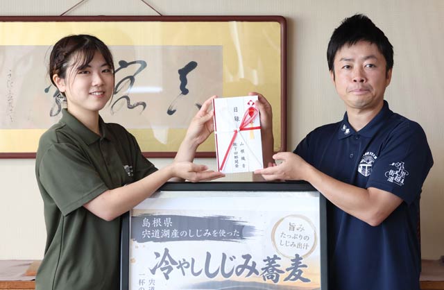 滝沢市長(右)に寄付を渡す山根さん