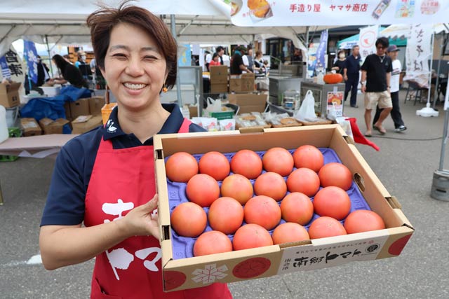 南郷トマトを手に奥会津振興センターの上杉主任事務局員